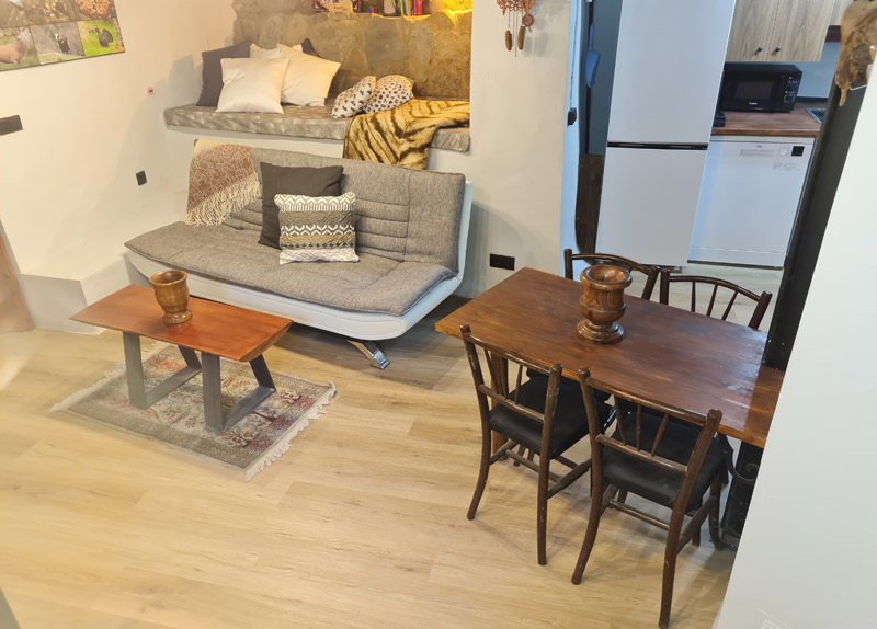 Apartamento rural con encanto en Borredà - mesa de comedor y sofá cama en el salón