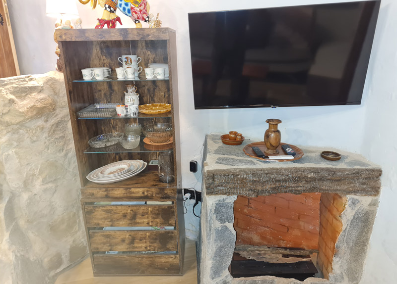 Apartamento rural con encanto en Borredà - televisor, chimenea y vitrina del salón