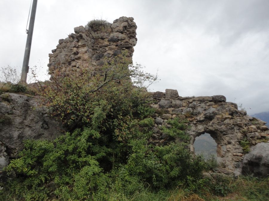 Lienzo de muro con la ventana apuntada del Castell Vell de Lillet entre la vegetación