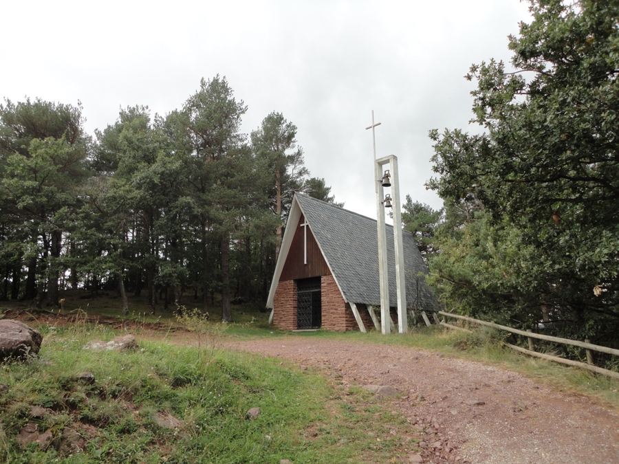 Église moderne de la Pietat, au toit d'ardoise descendant jusqu'au sol et au clocher isolé, à Castellar de n'Hug
