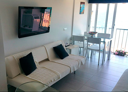 Alquiler turístico loft diseño Playa de Aro con mesa comedor salón y sofás cama