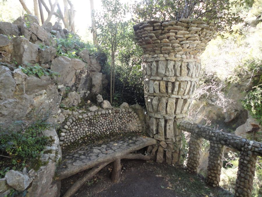 Banc de pedra amb respatller de còdols i columna en forma de copa als Jardins Artigas