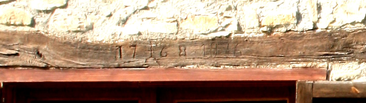 Dintel de madera de la masía El Pati con las fechas 1768 y 1976 grabadas