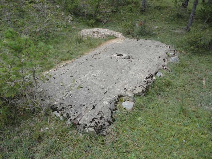 Pou del Xalet, gran losa de hormigón con un agujero en el centro entre la hierba