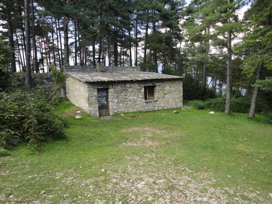 Refugi del Xalet, cabaña de piedra de una planta con tejado de losas, entre pinos