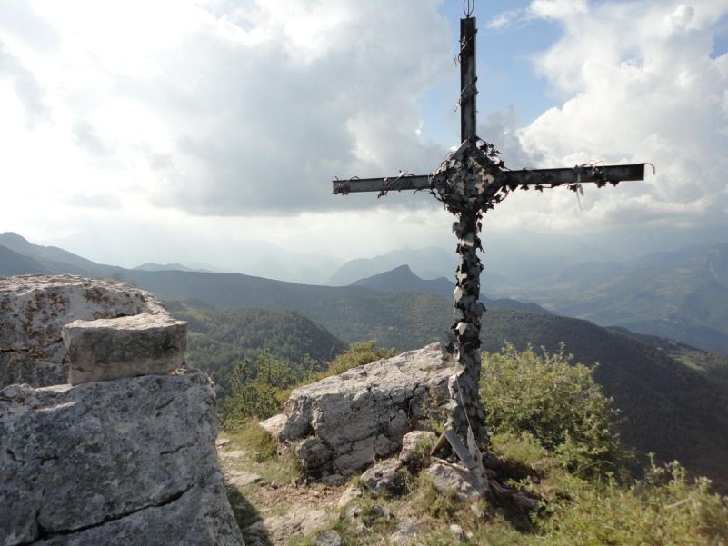 Creu de ferro al cim de la Roca de la Moreneta amb les muntanyes del Berguedà al fons