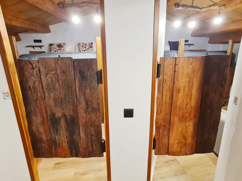 Tríplex Cal Barraqué de Dalt en Borredà - puertas batientes de madera de las habitaciones de la buhardilla