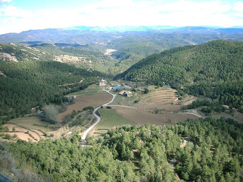 Vista hacia el sur desde el Roc de la Veu, con masías y campos en el valle