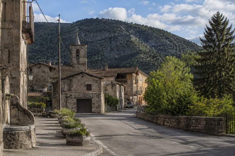 Vista panorámica diurna de Borredà con montaña y bosque en un ambiente tranquilo